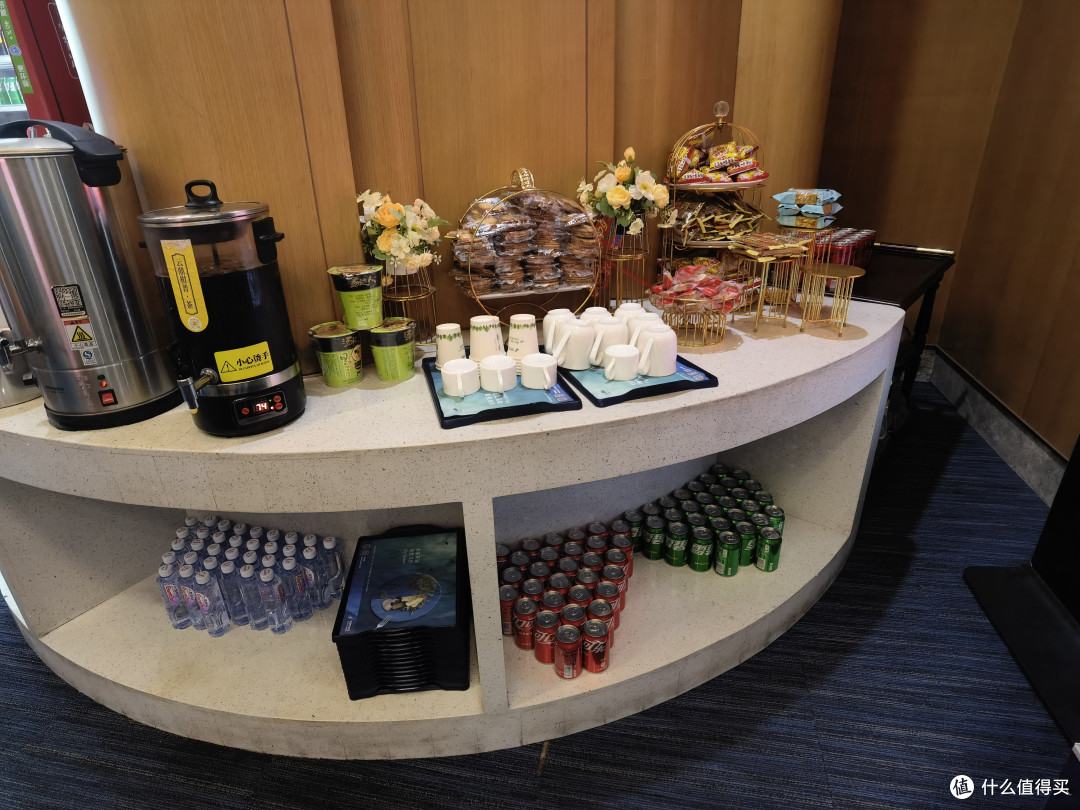 零食区里有热水、普耳茶，泡面、咪咪、饼干、沙琪码等，下面的柜子上摆放着饮用水、碳酸饮料