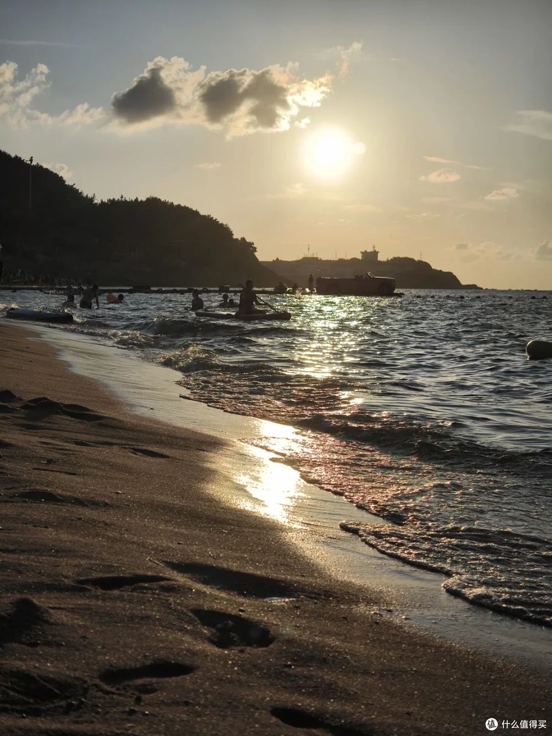 国际海水浴场的日落，金色夕照铺在涌浪与沙滩脚印上