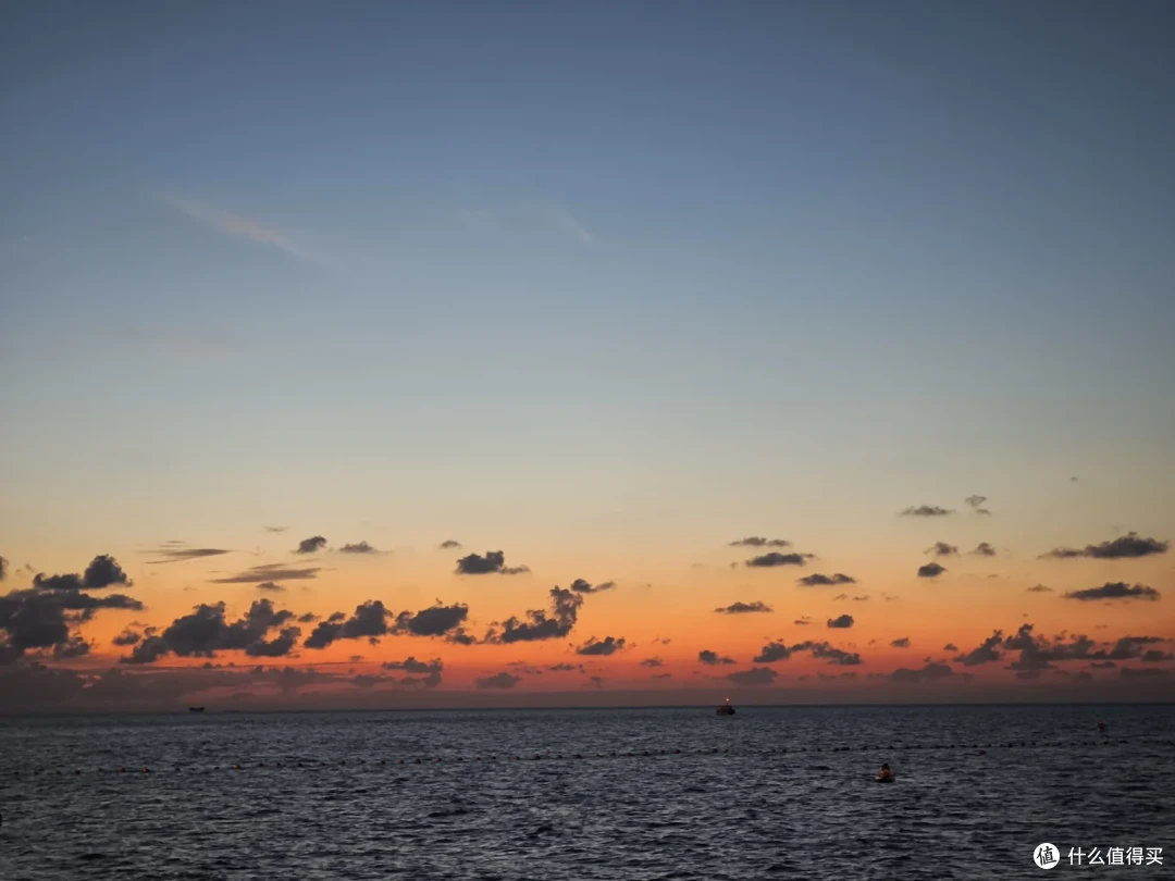 入夜前的国际海水浴场，橙红晚霞铺满海面与天际