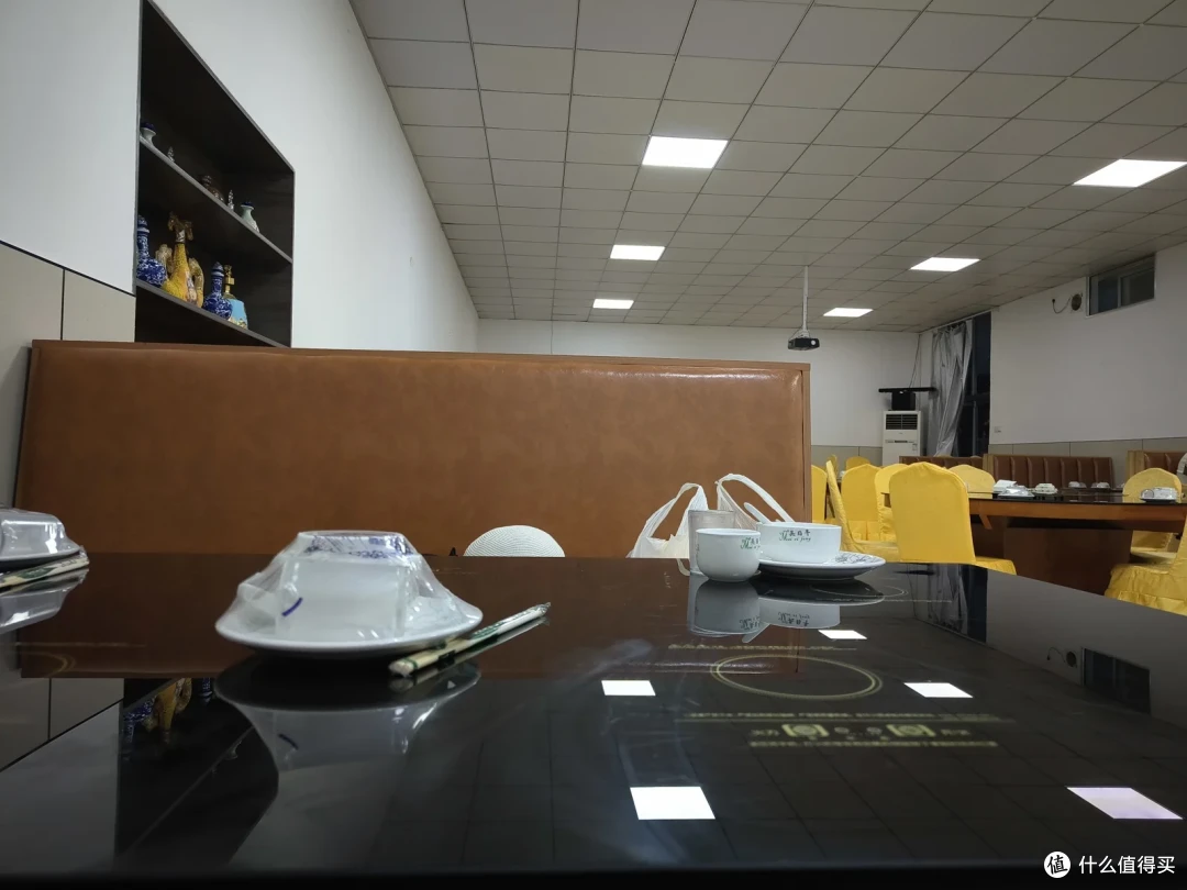 竹岛饭店由老房子改造的大厅，黄色椅套的餐椅配深色长桌，透着年代感