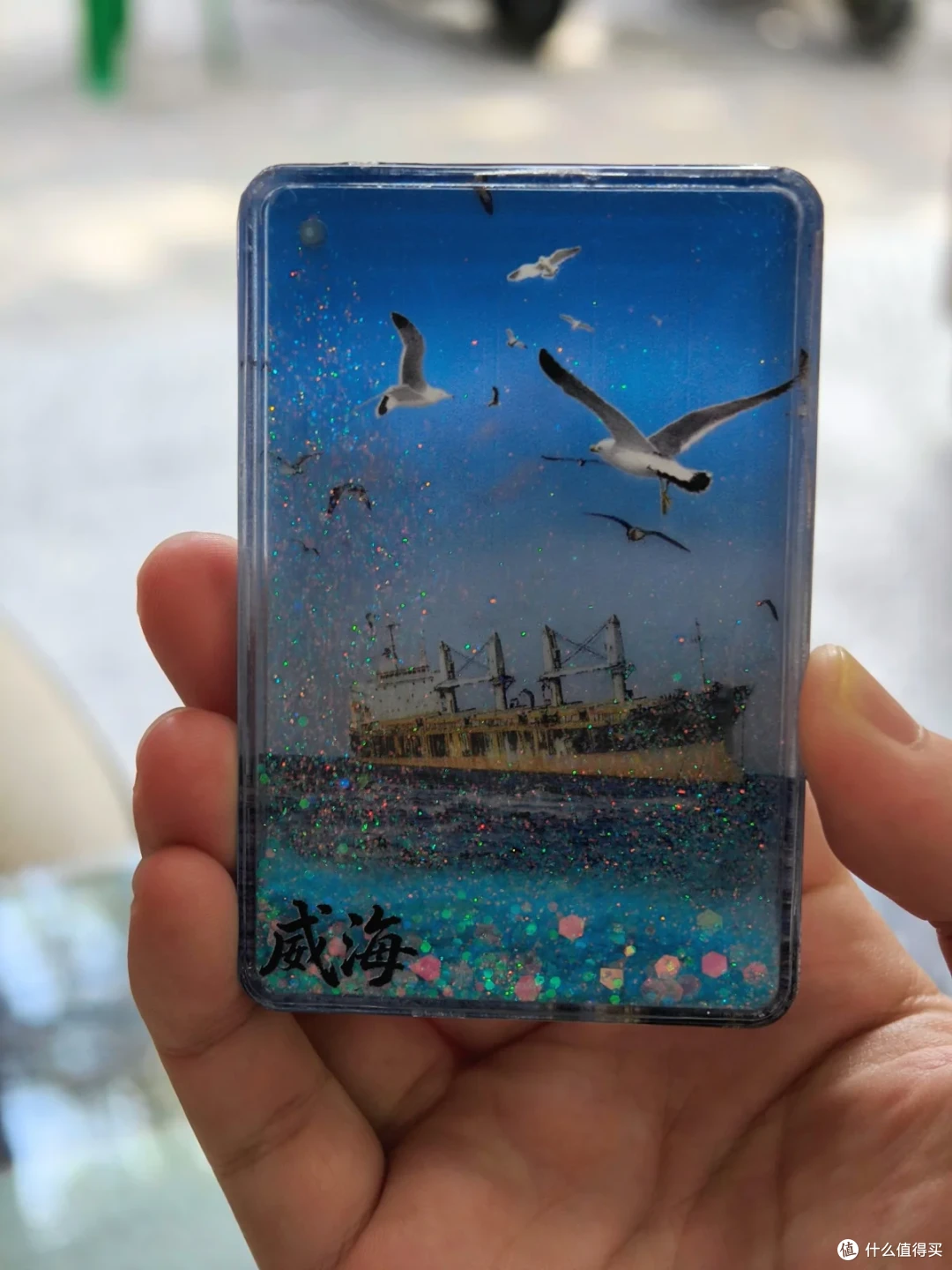 手握威海布鲁维斯号流沙纪念品，蓝色闪粉中海鸥飞过搁浅货船