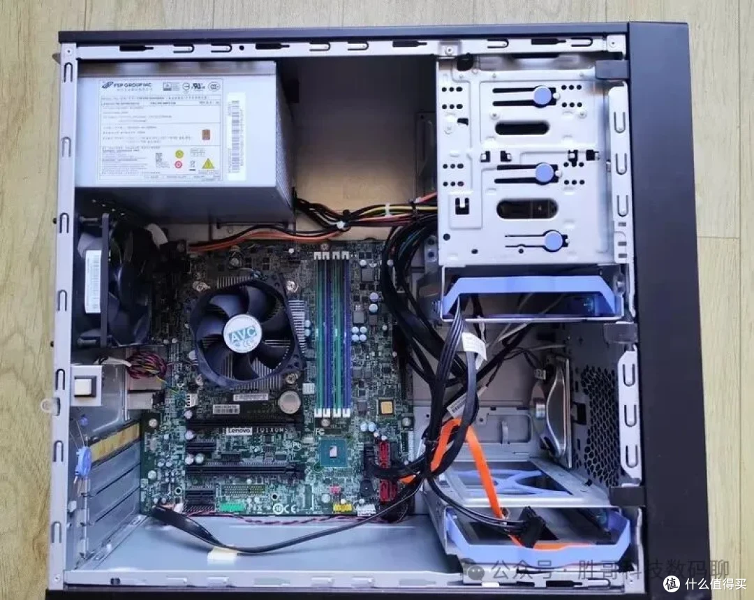 联想 ThinkStation P320 塔式机箱内部实拍（左上为 FSP 全汉代工电源，左侧 AVC CPU 散热器，主板四条 DDR4 内存槽与 PCIe 插槽，右侧两个 5.25 寸位和蓝色免工具硬盘托架）