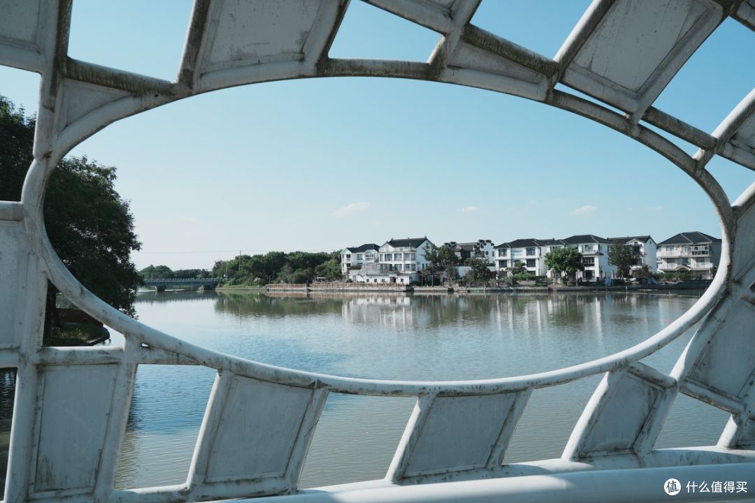 同一个湖景，从拱桥的椭圆开口里往外拍，色调明显冷了下来