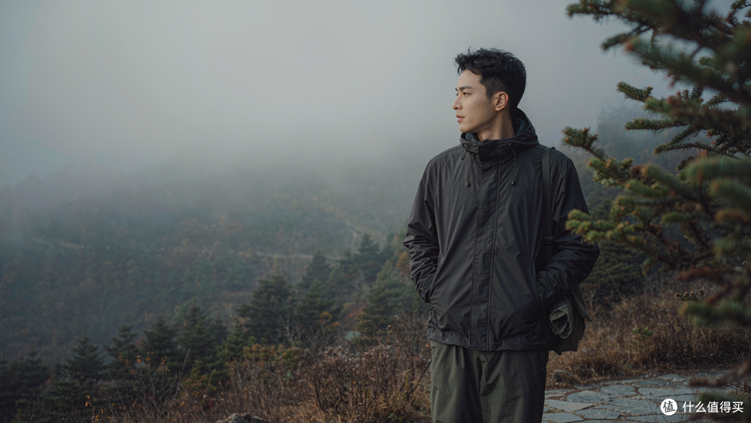 低饱和的深色，让人的轮廓安静地融进山色里，而不是压在风景之上。