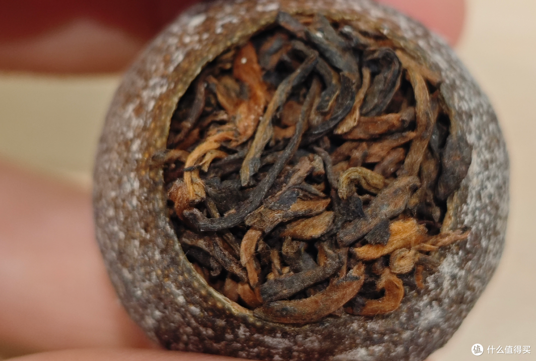 掰开小青柑，里面熟普的条索、金芽和干净程度，比外皮更说明问题